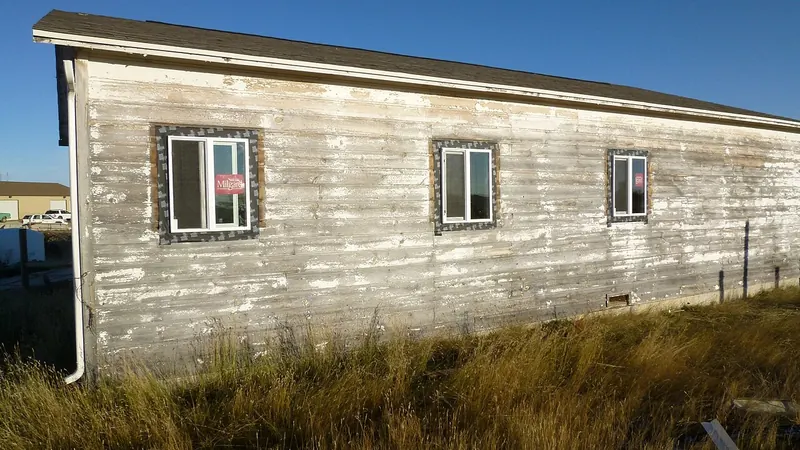 Weathered painted wood siding on an old building