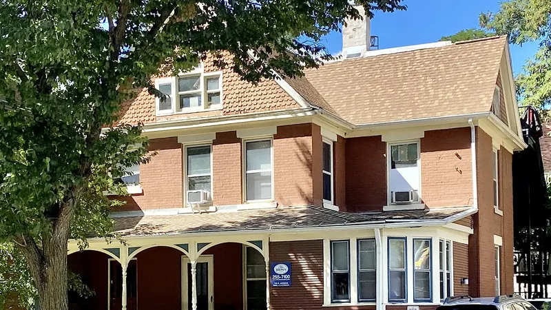 Brick house with a front porch and a gray shingle roof